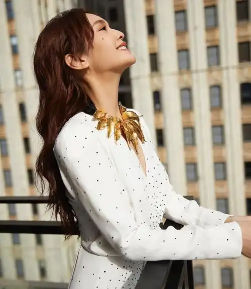 杨丞琳出席某活动,身穿白色深v礼服,戴的金叶子项链,独特别致