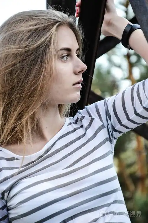 女孩 poing 在相机上, 看着侧面.户外