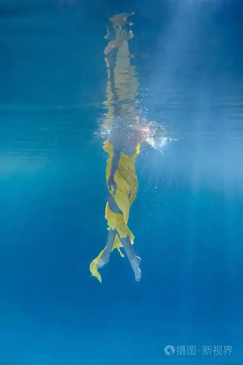 女子穿着衣服在水下游泳的局部景观