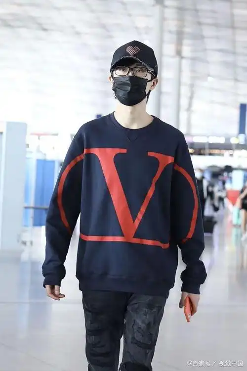 许嵩穿深蓝色卫衣亮相机场 棒球帽上红桃心可爱抢眼