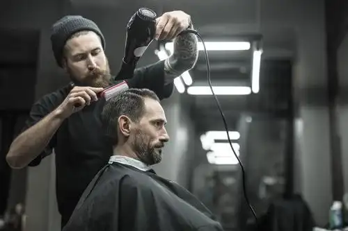 理发店背景下绿色瓶子的液体倒在男人的手上素材-高清图片-摄影照片