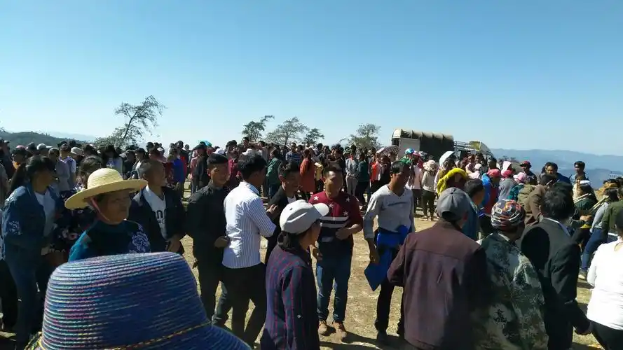 一个山头,一群人,在灿烂喜气的阳光下围在一起庆祝新春.