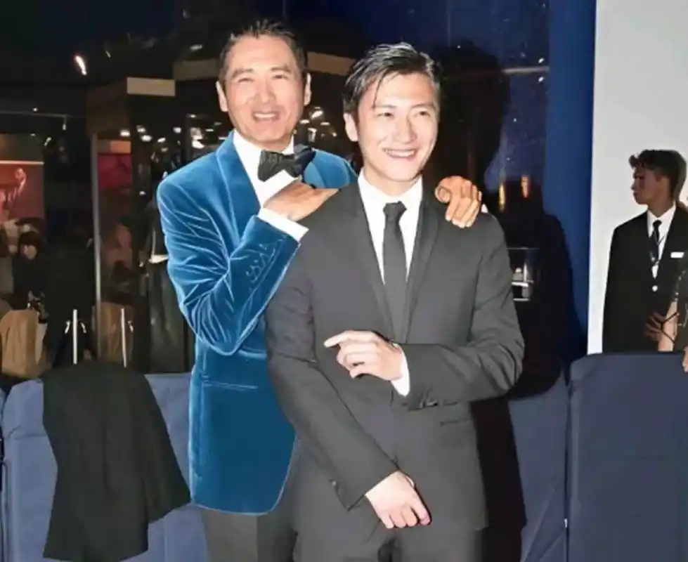 1982年,27岁的发哥抱着2岁的谢霆锋,两人都是呆萌可爱.