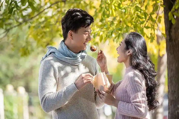 快乐的年轻情侣吃街头小吃