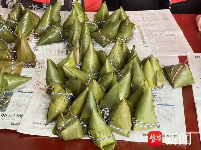 巾帼志愿者早早地来到活动现场,做着包粽子的准备工作,把提前泡好的