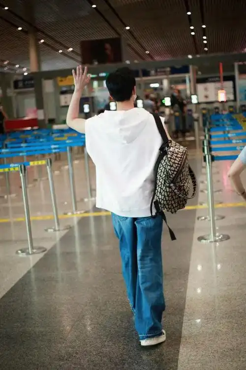 杨洋出发看秀机场路透白色无袖连帽衫牛仔裤造型