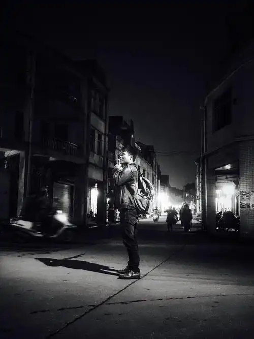 11,广东省阳江市,夜色下,在十字路口停下抽烟的旅者在考虑走哪一个