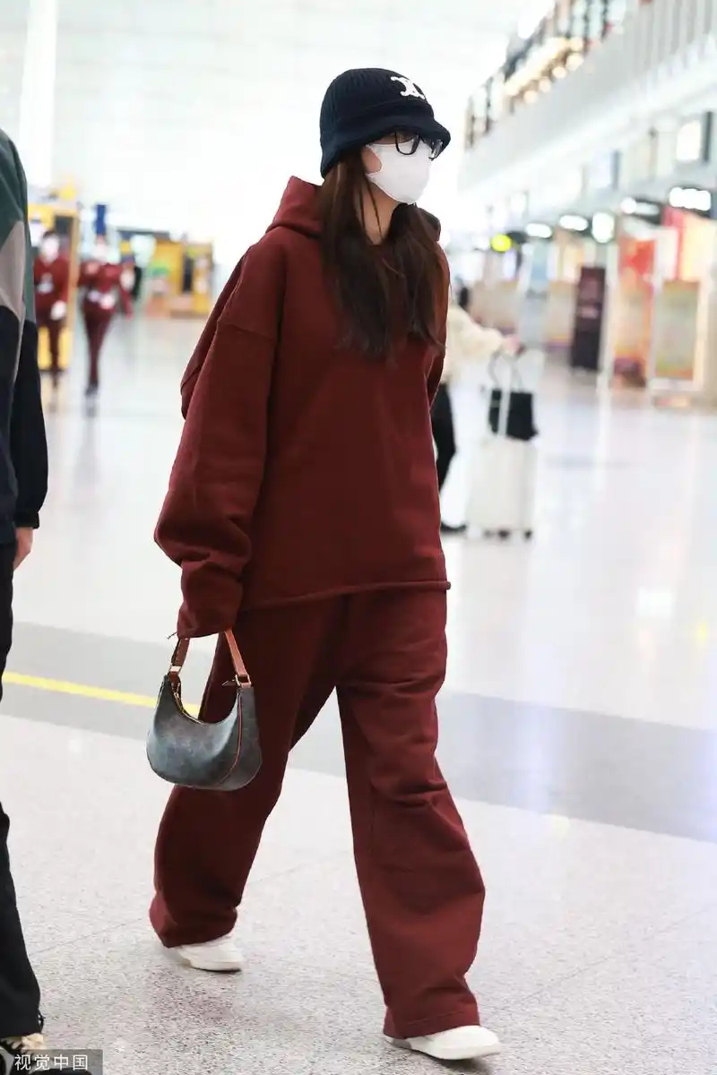 组图:孙怡穿酒红色运动套装现身首都机场 戴渔夫帽低调出行