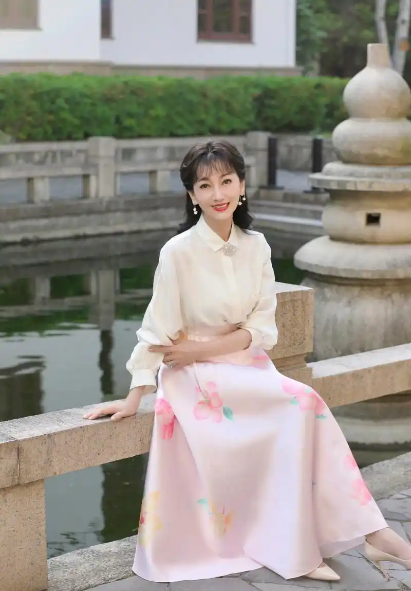 赵雅芝,白色衬衫搭配粉色高腰裙,粉红色花卉图案,显得好年轻,完全看不
