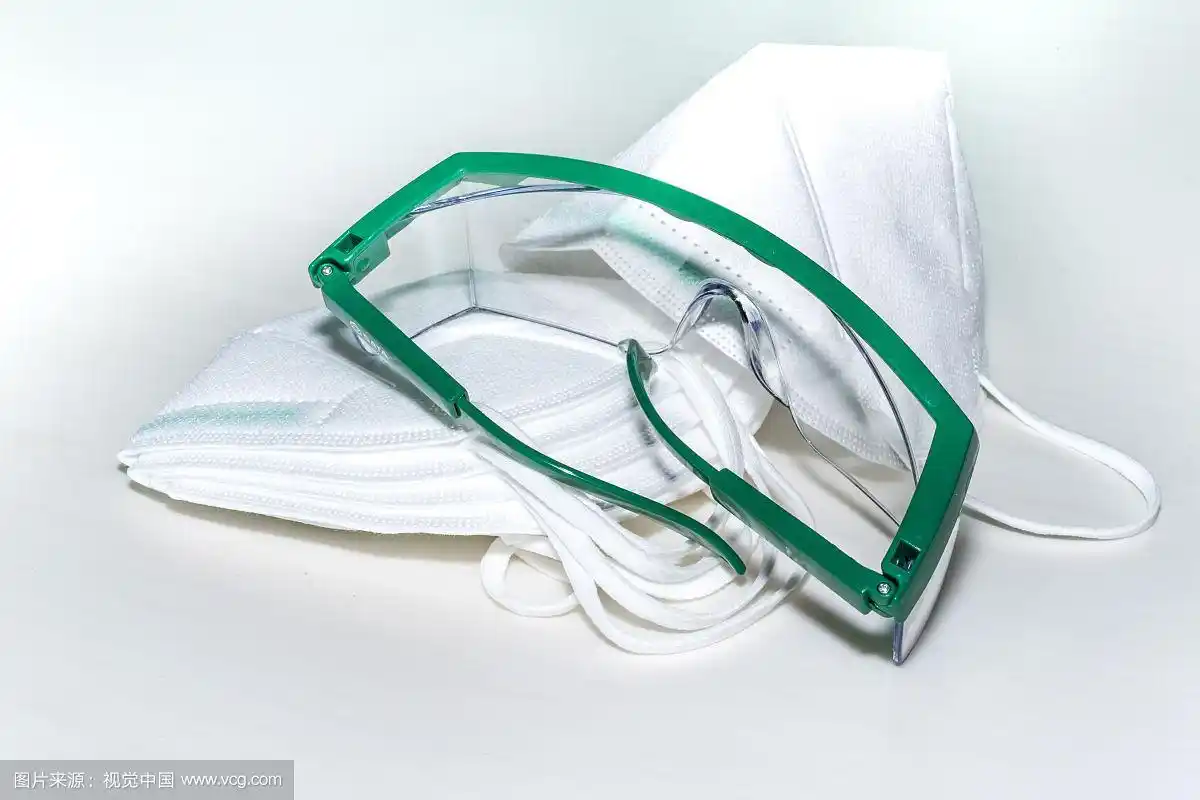 白背景板上的口罩与护目镜