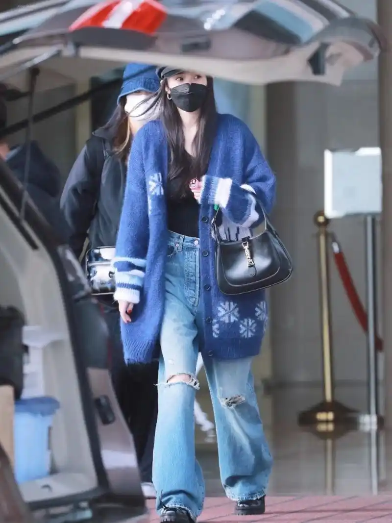 杨幂在机场的街拍中展示了她的私服风格,身穿蓝色针织衫搭配牛卓沣