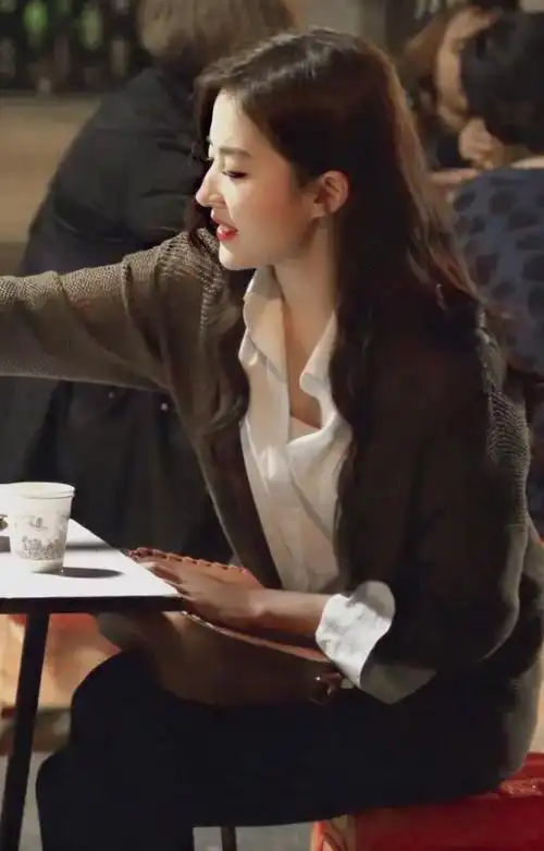 在这个造型中刘亦菲采用了叠穿的方法,将白色衬衫穿在灰色开衫里面