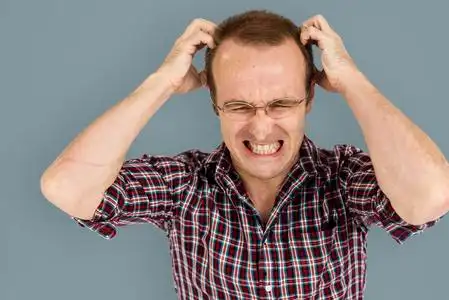 在抓头的眼镜的男人照片