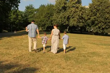 幸福生活背影一男一女穿着夏装,两个儿子和一个抱着小孩的爸爸正走在