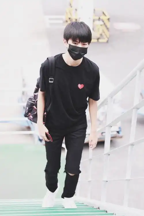 王俊凯身着全黑混搭现身机场,红色小爱心引人注目
