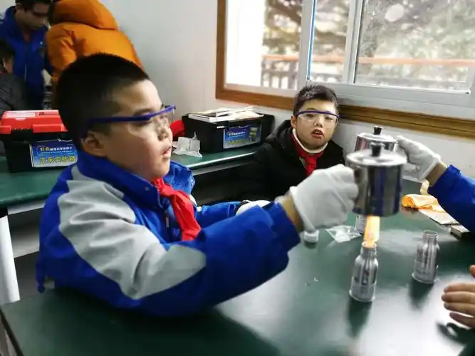 孩子们戴着眼镜,戴着手套,规范的操作实验.