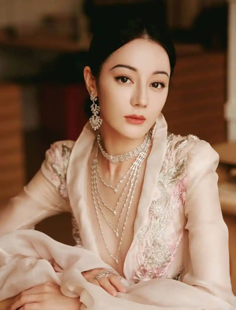 迪丽热巴参加盛典的造型图展现了她的优雅气质和时尚品味,大v领礼服让