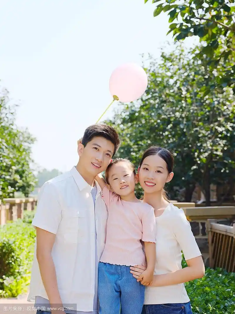 快乐的三口之家在户外合影