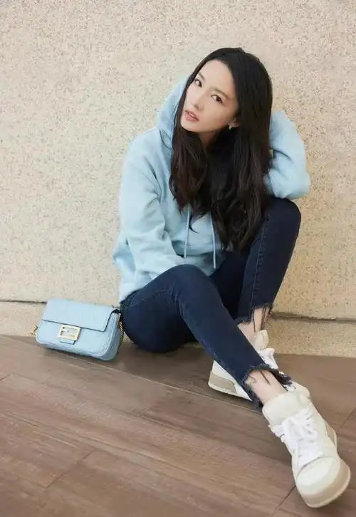 李沁穿冰蓝连帽卫衣配修身裤脚撕裂牛仔裤又美又酷还减龄