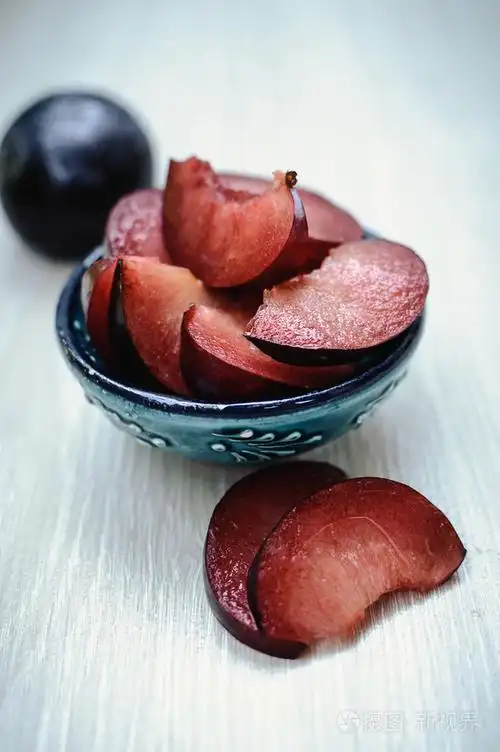 在盘子上切成熟李子