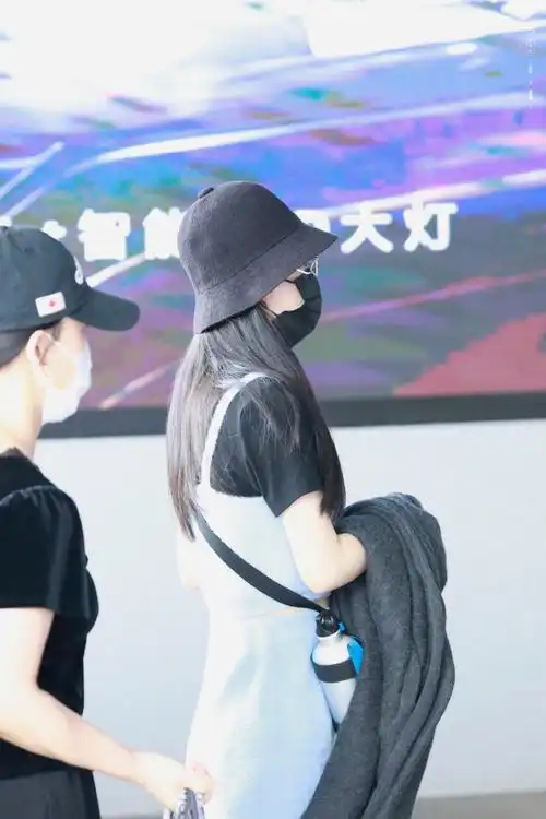 赵丽颖机场出发饭拍蓝色背带裙搭配黑色渔夫帽 清爽夏日感吸睛美腿