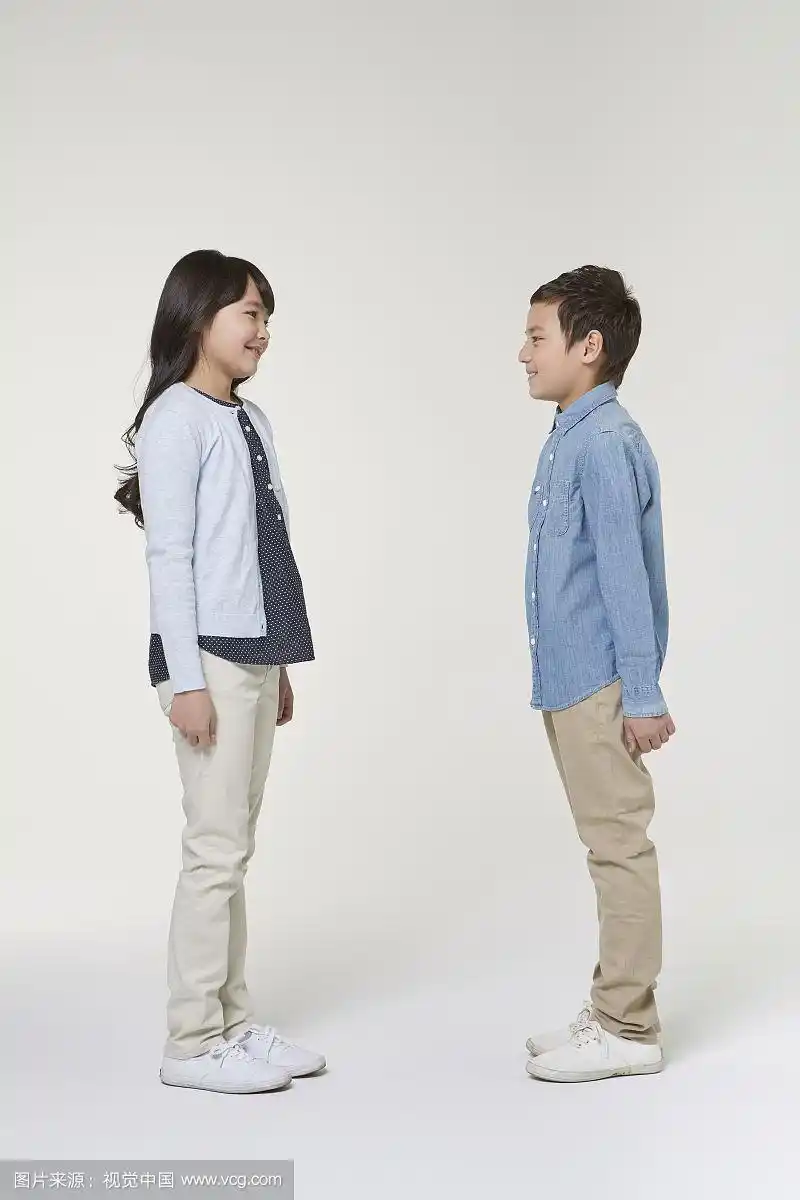 少年男孩和女孩面对面站立的摄影