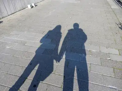 一对夫妇的影子, 男人和女人牵手在街上照片