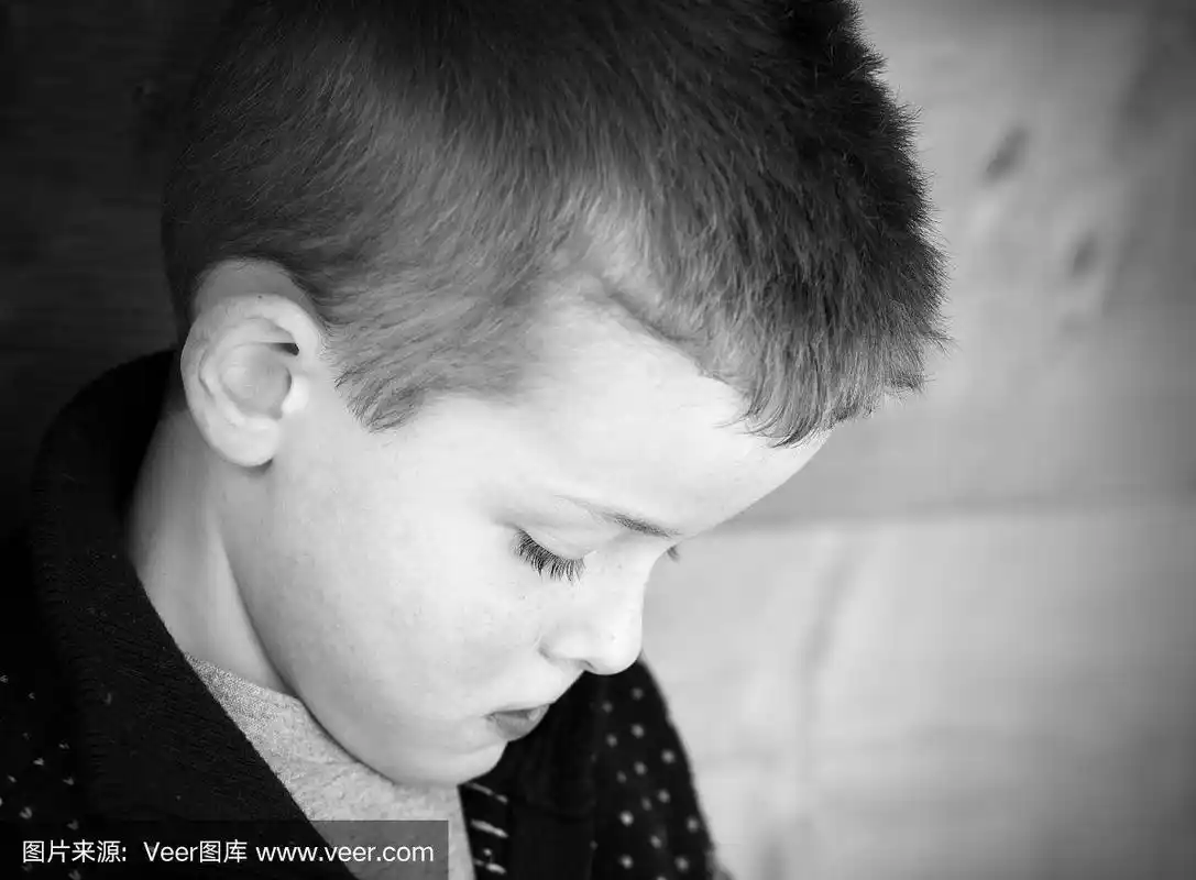 沮丧的小男孩低头看着地板