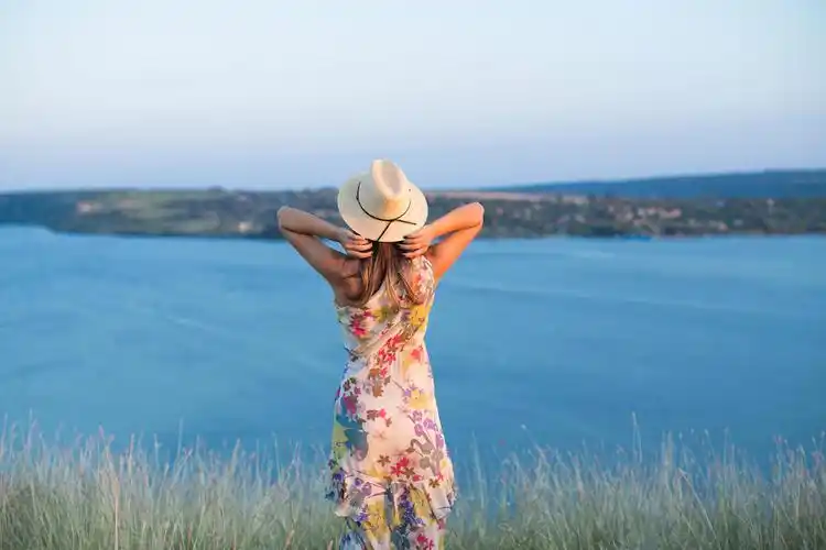 站在崖边的山羊蓝天大海背景男子张开双臂在悬崖的边缘上悬崖边明亮的