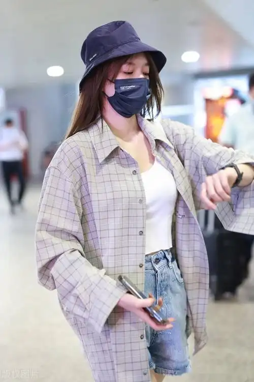 程潇现身北京机场,身穿白色吊带上衣牛仔短裤方格小褂超女范十足