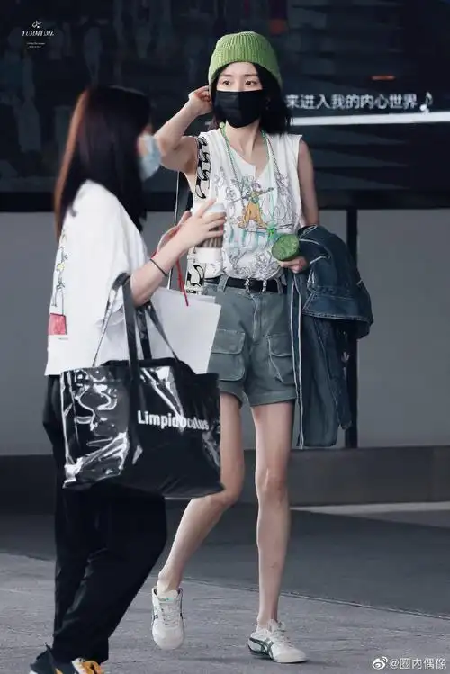 杨幂手里拿着莲蓬#杨幂今日机场出发饭拍,背心短裤绿色毛线帽,今天是