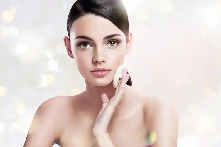 模糊发光背景正在化妆拍粉扑的漂亮欧美女人