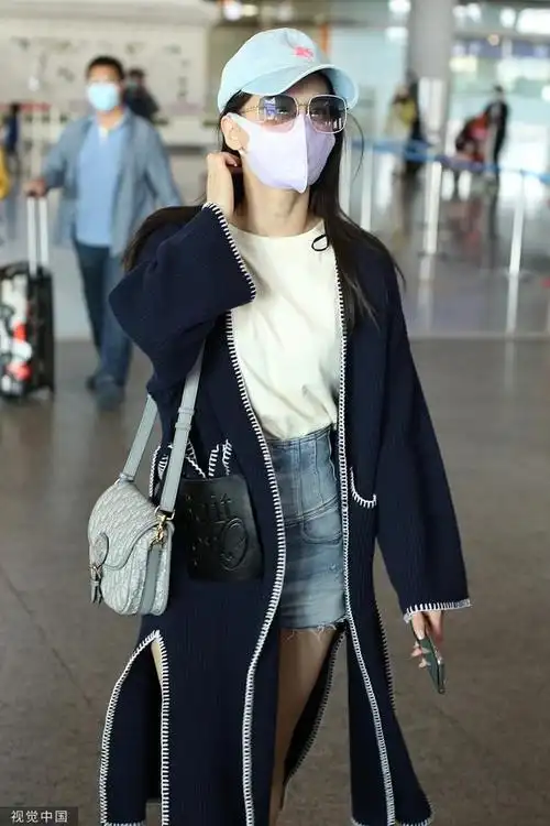 黄圣依身穿长款开衫搭配牛仔短裤,美腿吸睛,戴棒球帽大步流星,气场超