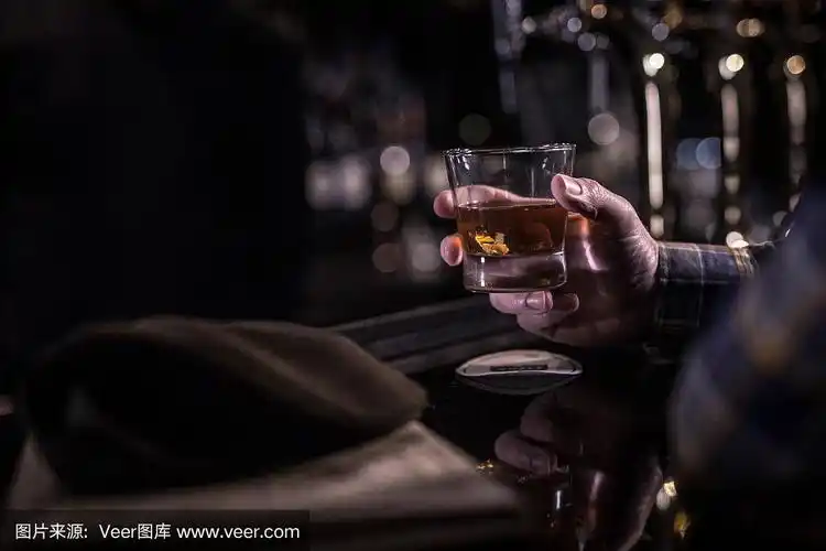 黑暗的吧台前,一个老男人手里拿着威士忌酒杯
