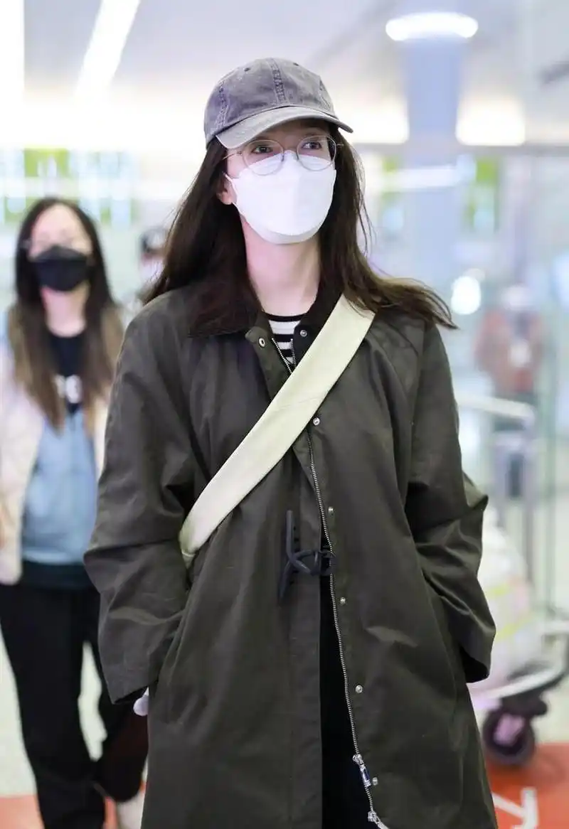 江疏影机场街拍,军绿色的大衣搭配条纹t恤,头戴棒球帽清新又减龄.