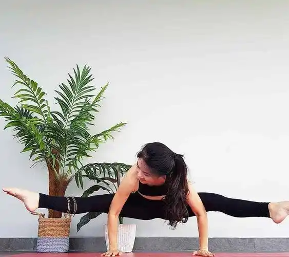 双腿绷直,在瑜伽垫上做出一字马的动作.