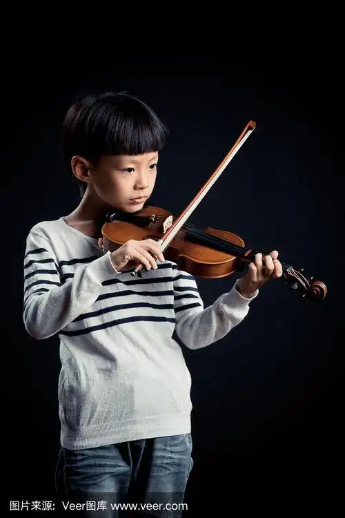 一个男孩在黑色的背景下独自拉着小提琴