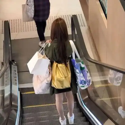 内搭白色打底衫,下身穿黑色超短热裤,秀出一双纤细大长腿;从背影来看