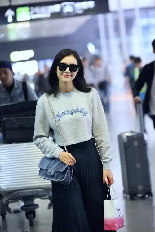 原创高圆圆走机场妩媚撩发显青春穿卫衣搭配百褶裙优雅时尚