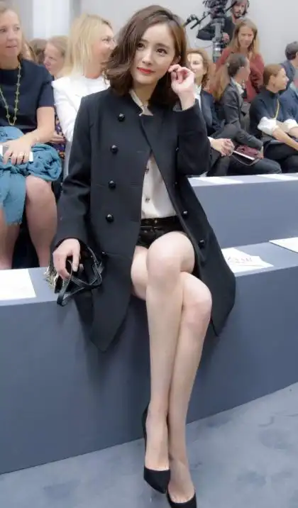 外搭一件黑色大衣,脚踩黑色尖头高跟,微卷