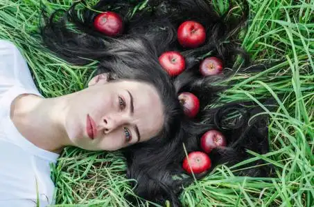 地上的头发. 头发上的红苹果. 夏天的心情回忆. 自然营养健康.照片
