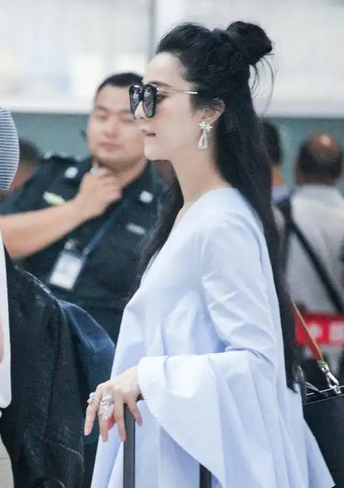 范冰冰扎丸子头现身机场咬下唇卖萌
