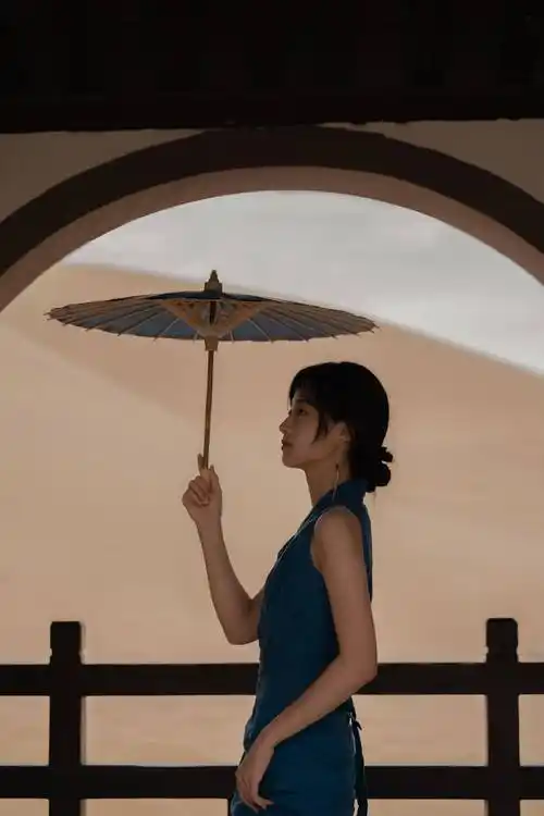 身穿蓝色长裙的她,化着淡淡的妆,手拿纸伞,仿佛江南水乡的美人!