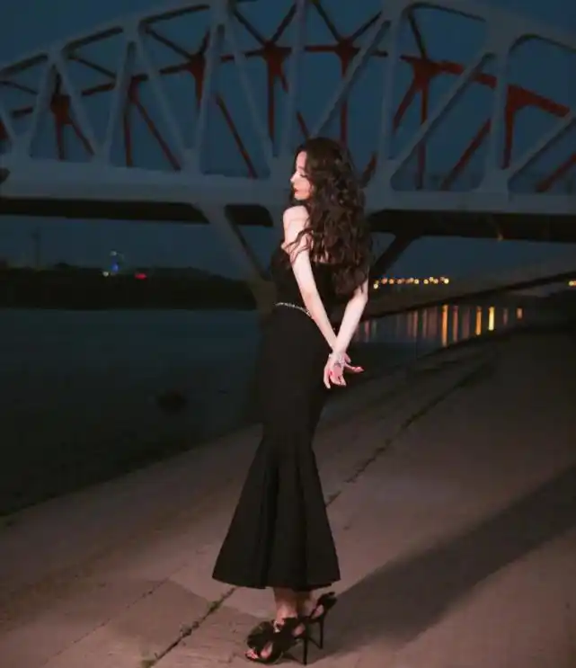 杨幂身穿黑色鱼尾裙,曼妙身姿朦胧妩媚,江边的她比夜色更撩人