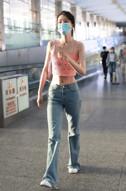 粉色吊带背心搭配蓝色牛仔裤乔欣机场走秀美出新境界
