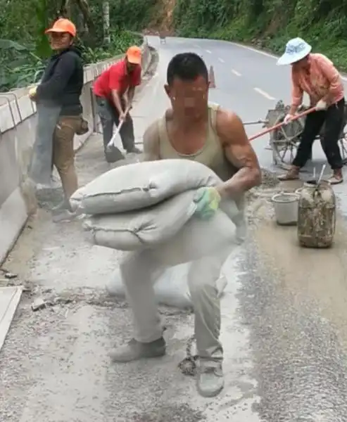 肩膀上扛的是责任嘴里咬的是爱情小伙儿肩扛两袋水泥嘴叼一袋