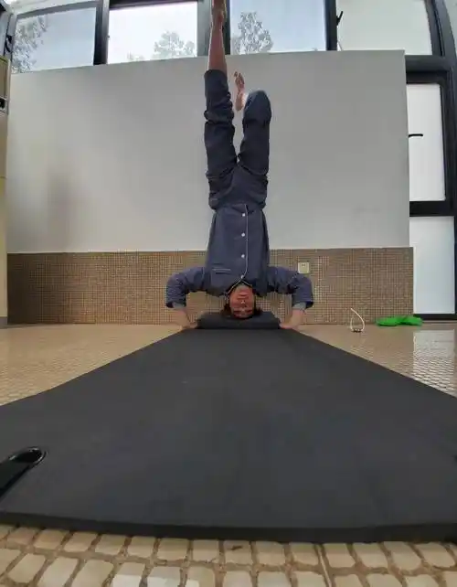 照片当中的陈学冬处于倒立的状态,地上只铺上了一个瑜伽垫,两只脚是在