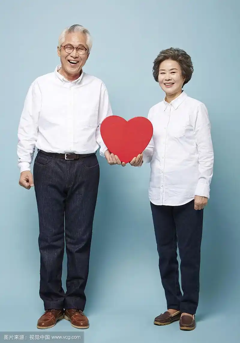 老年夫妇手捧心形相框合影