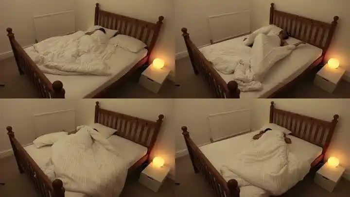 一个年轻人夜晚在床上翻来覆去的画面.