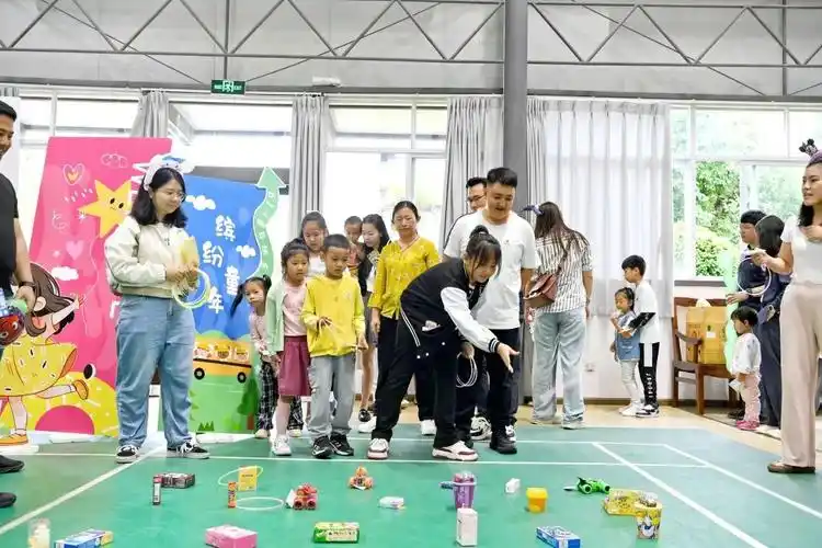 体育馆内欢笑声此起彼伏,家长与孩子正在积极参与"小脚踩大脚""风生球